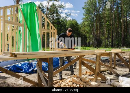 Engineer working with machine on plank at construction site Stock Photo