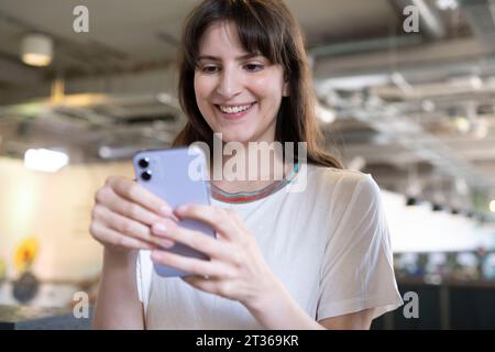 Smiling woman using smart phone Stock Photo