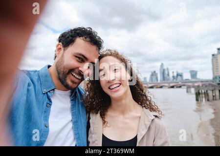 Happy loving couple taking selfie in front of river Stock Photo