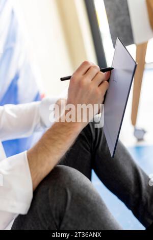 Hand of businessman writing with digitized pen on tablet PC Stock Photo
