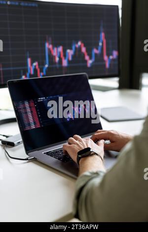 Hands of businessman working on laptop at desk Stock Photo
