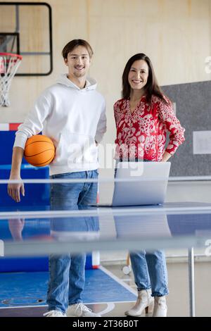 Happy young trainee standing with businesswoman in office Stock Photo