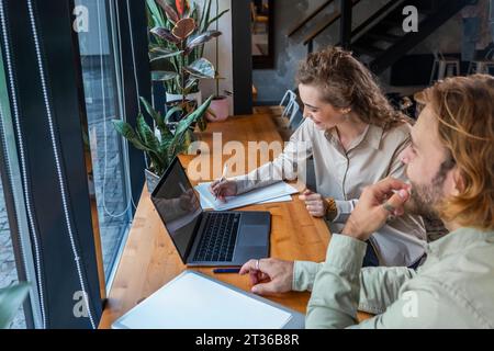 Businesswoman preparing notes with colleague at cafe Stock Photo