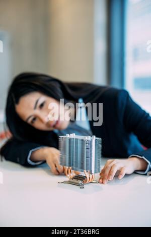Engineer analyzing semiconductor at desk in office Stock Photo