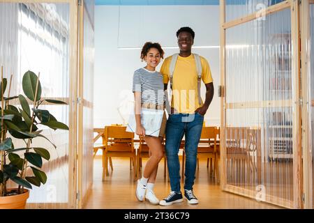 Smiling students standing together in doorway at university Stock Photo