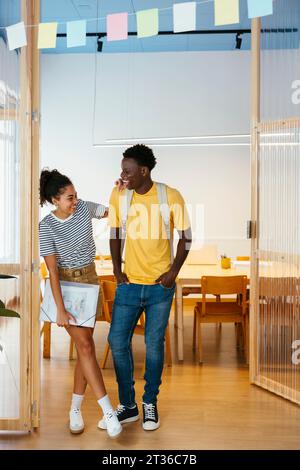Happy students standing together in doorway at university Stock Photo