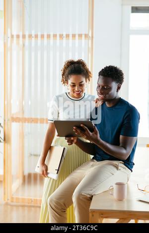 Smiling young students using tablet PC at university Stock Photo