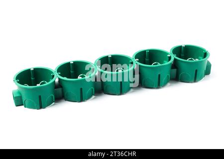 Green plastic socket boxes for mounting electrical devices in a concrete and brick wall Stock Photo
