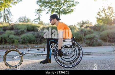 Mature athlete racing with wheelchair in competition on road Stock Photo