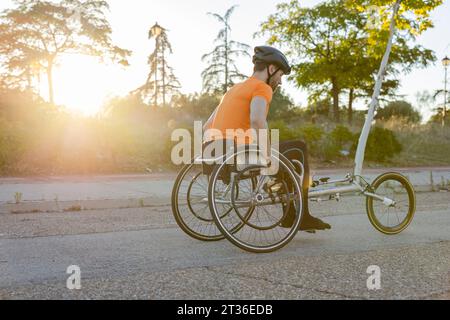 Athlete participates in wheelchair racing competition on road Stock Photo