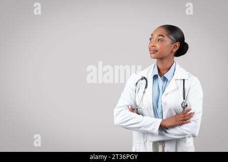 Confident female doctor with stethoscope, looking thoughtful Stock Photo