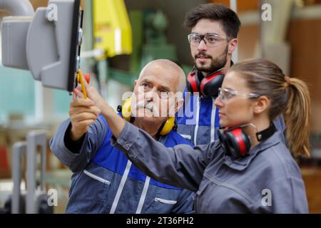 apprentices being shown computer control panel in factory Stock Photo