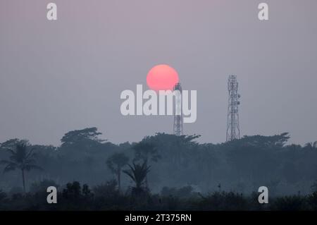 The sun setting behind a cell tower.this photo was taken from khulna,Bangladesh. Stock Photo