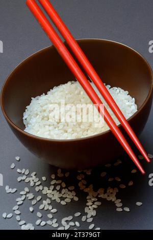 Rice, white rice in bowl with chopsticks, uncooked Stock Photo