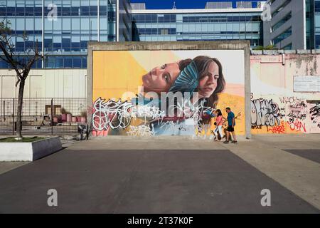 Pedestrians passing a mural and graffitis on the wall.Puerto Madero.Buenos Aires.Argentina Stock Photo