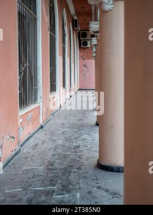 Colonnade in the old town. Corridor near the columns. The architecture and air conditioners are old. Part of the architectural ensemble Stock Photo