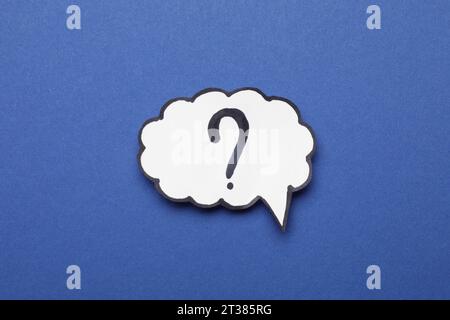 Paper speech bubble with question mark on blue background, top view Stock Photo