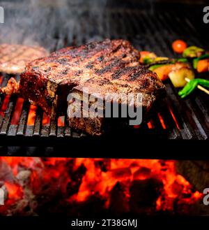 Steak on charcoal grill with vegetables Stock Photo