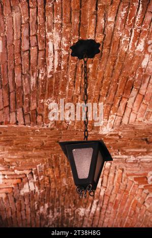 Old fashioned lantern hanging from the brick wall Stock Photo