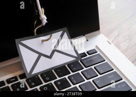 Closeup image of mail with hook on top of keyboard. Phishing email, malware and cyber security concept Stock Photo