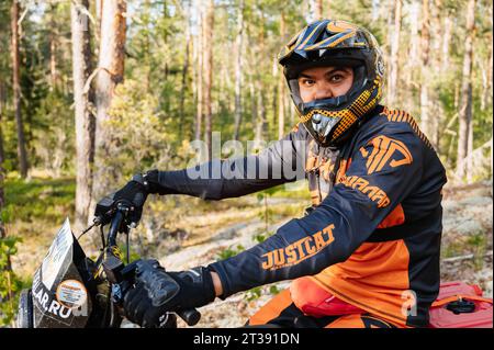 REPUBLIC OF KARELIA, RUSSIA - CIRCA JUNE, 2022: Off-road tournament Ladoga Trophy 2022 in Karelia. Portrait of a motorcycle racer in a helmet sitting on a sports motorcycle during a race Stock Photo