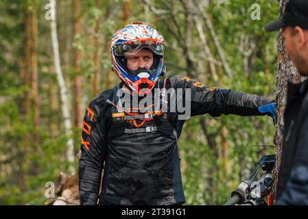 REPUBLIC OF KARELIA, RUSSIA - CIRCA JUNE, 2022: Off-road tournament Ladoga Trophy 2022 in Karelia. Portrait of a motorcycle racer in a helmet before the start of the race Stock Photo