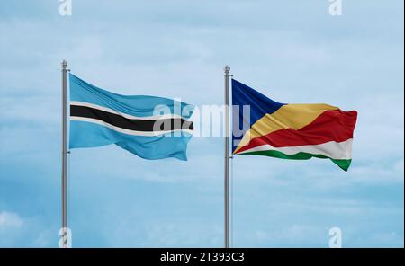 Botswana and Seychelles flags waving together on blue cloudy sky, two ...