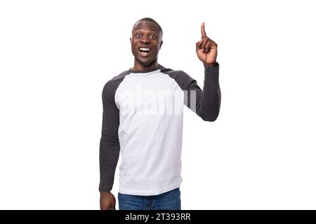 young positive african man dressed in a spring jacket tells interesting news and points with his hands Stock Photo