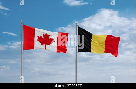 Belgium and Canada flags waving together on blue cloudy sky, two country relationship concept Stock Photo