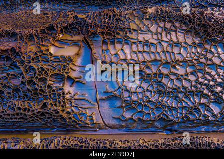 Closeup of textured surface of rough rocky formation with cracks as abstract background Stock Photo