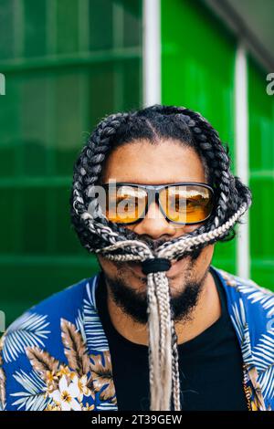 Portrait of a smiling latin man with a knot of his hair braided in his face in close-up view. Stock Photo