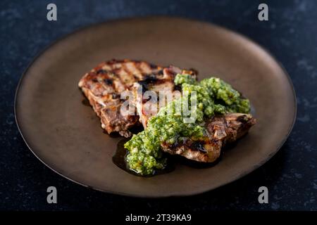 Iberian pork chops with thyme, lemon and pesto Stock Photo
