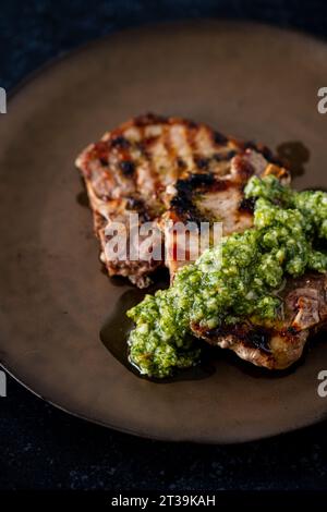 Iberian pork chops with thyme, lemon and pesto Stock Photo