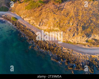 Aerial view of a narrow coastal road winding around the base of a cliff at Victor Harbour on the Fleurieu Peninsula in South Australia Stock Photo