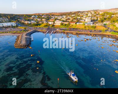 Aerial view of a fishing boat leaving a boat ramp along a residential waterfront at Victor Harbour on the Fleurieu Peninsula ion South Australia Stock Photo