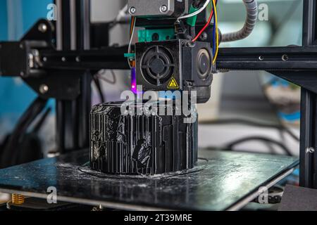 A 3D printer prints a black model. Technology at home Stock Photo