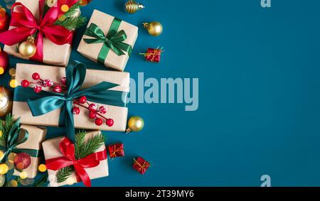 Holiday blue background with gift boxes tied with silk ribbons and Christmas decorations. Christmas holiday background. Top view with copy space. Stock Photo