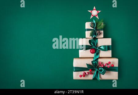 Three gift boxes on a green background in the shape of Christmas tree and  Christmas star. Holiday background. Stock Photo