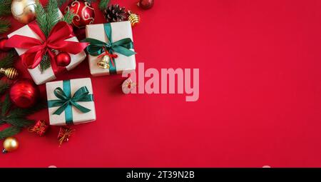 Holiday red background with gift boxes and Christmas decorations. Christmas holiday background. Top view with copy space. Stock Photo