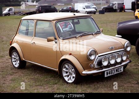 Three-quarters front view  of a Gold, 2000 Rover produced Mini Cooper S, Knightsbridge Edition, on display at the 2023 British Motor Show, Farnborough Stock Photo