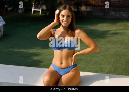 Leisurely Lounging: Woman in Poolside Swimsuit Stock Photo