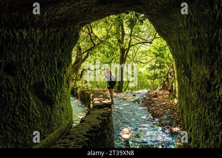 Eine junge Frau beim Trekking in der Höhle von Levada do Caldeirao Verde, Queimadas, Madeira Stock Photo