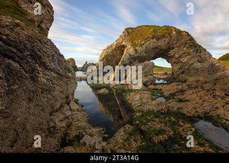 Ballintoy, Northern Ireland is a picturesque fishing village with a dramatic coastline and many sea stacks made of basalt, a type of volcanic rock. Stock Photo