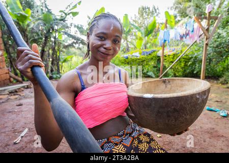 Smiling young African villager lady ready to pound some carbohydrate for her family meal. Stock Photo