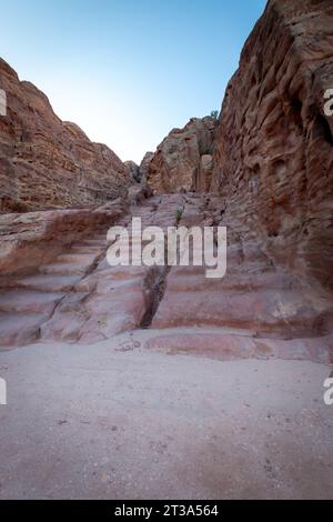 Stairs in the rock along Al Kubtha Trail (Indiana Jones Trail) leading to Al-Khazneh Treasury in the historic and archaeological city of Petra, Jordan Stock Photo