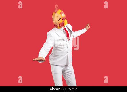 Guy wearing suit and funny chicken head dancing and having fun at crazy animal party Stock Photo