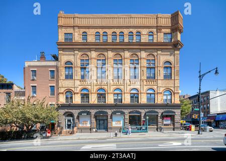 Park Slope, Brooklyn: Acme Hall, a Romanesque Revival building with elaborate brickwork, tall transom-topped windows, and corner tower. Stock Photo