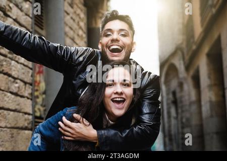 Diverse people celebrating at camera together in city street - Transgender person laughing with friend outside - Youth community concept Stock Photo