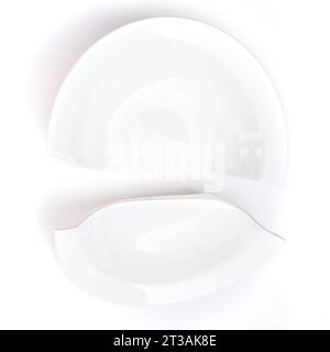 Two halves of a white plate broken in half on a white background. Stock Photo