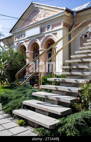 Side view of concrete stairs made in 80s design, with a retro architecture style house in the background Stock Photo